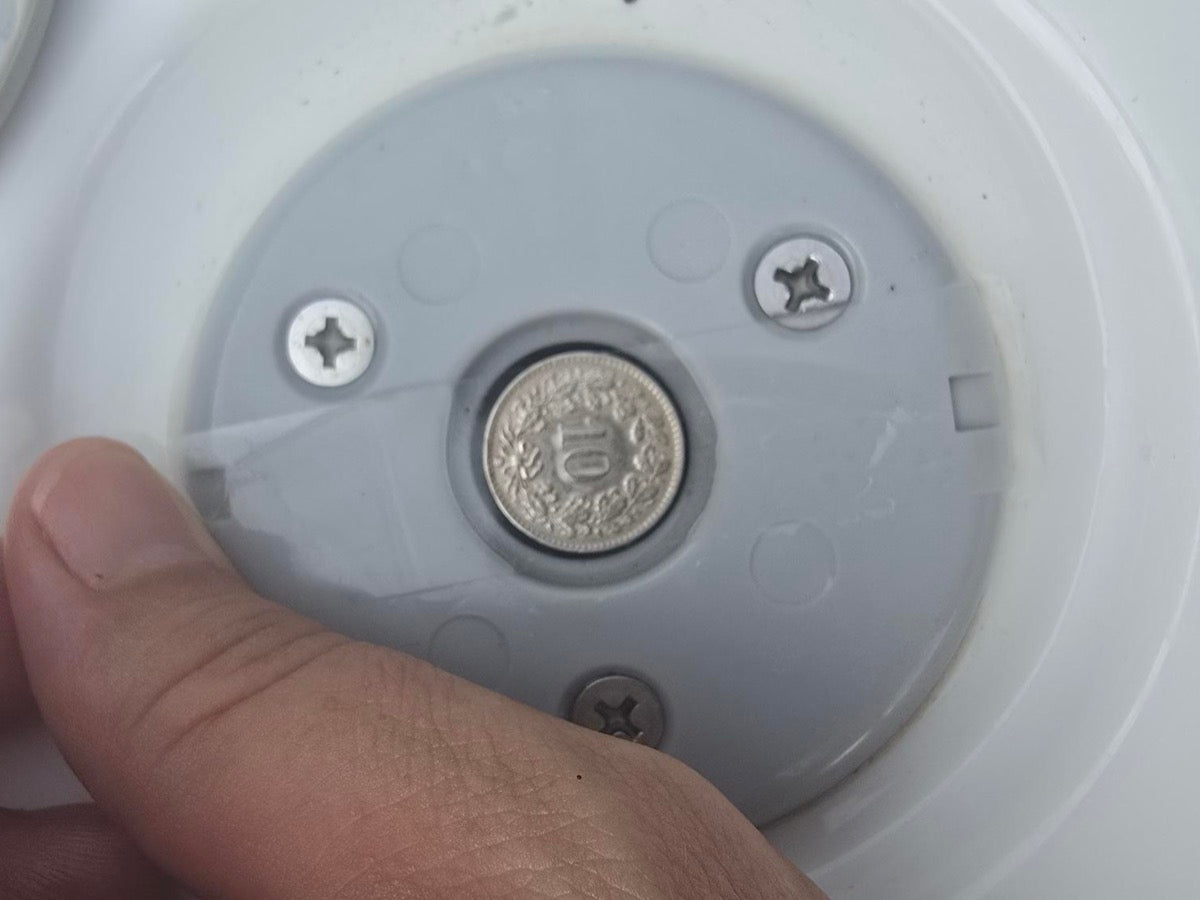 10-Rappen coin lying flat inside a factory swim-spa base socket — a passing coin test